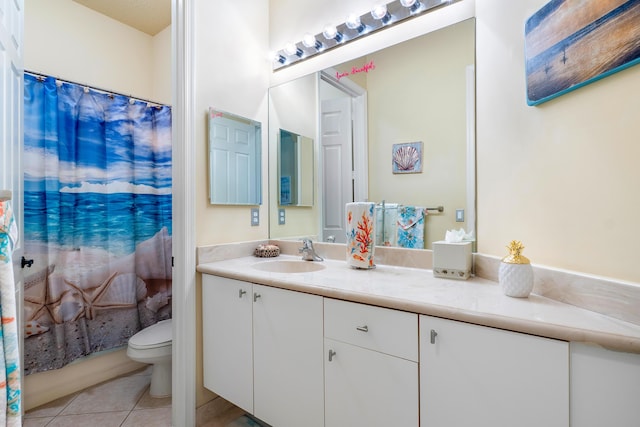 bathroom with toilet, vanity, and tile patterned floors