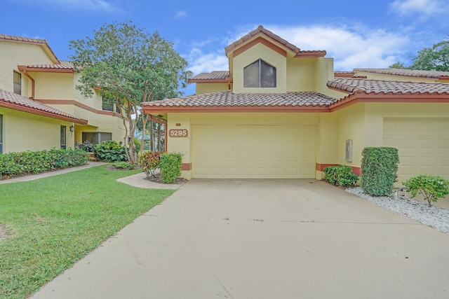 mediterranean / spanish-style home featuring a garage and a front yard