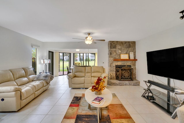 tiled living room with ceiling fan and a fireplace