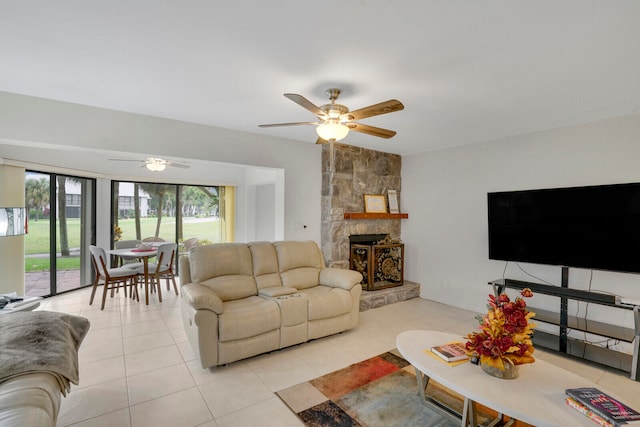 tiled living room with ceiling fan and a fireplace