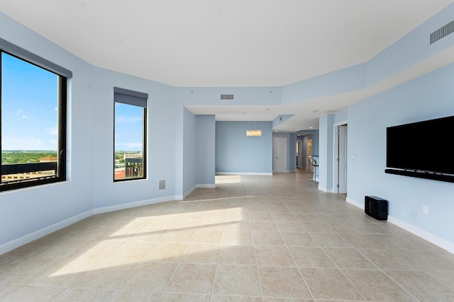 unfurnished living room with light tile patterned flooring and a chandelier