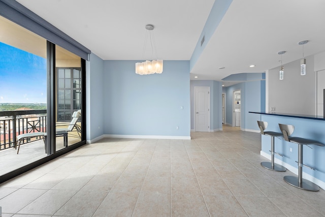 empty room featuring floor to ceiling windows, light tile patterned flooring, and an inviting chandelier