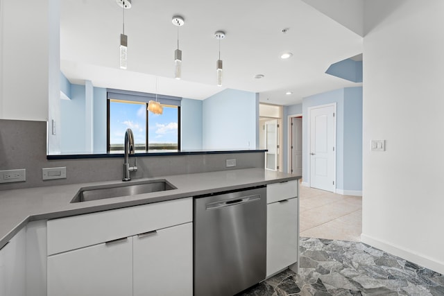 kitchen featuring stainless steel dishwasher, white cabinets, sink, and hanging light fixtures