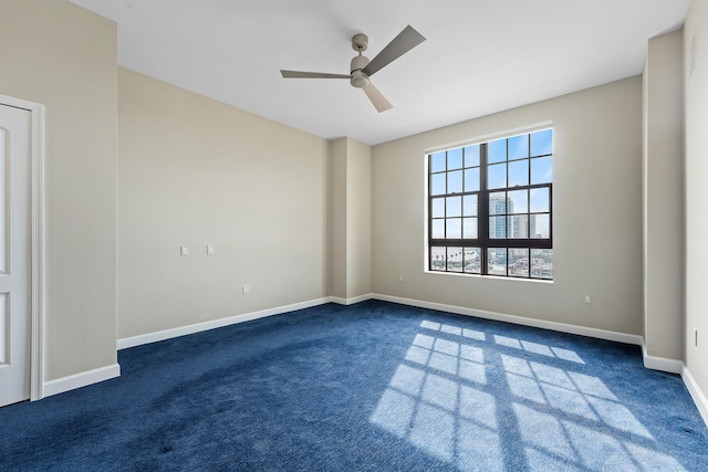 unfurnished room featuring ceiling fan and dark colored carpet