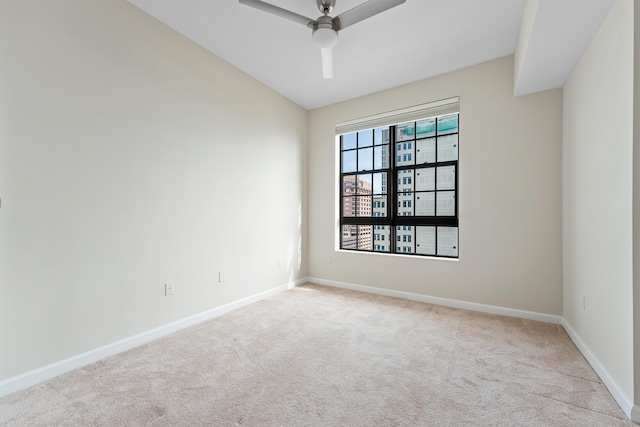 spare room with ceiling fan and light colored carpet