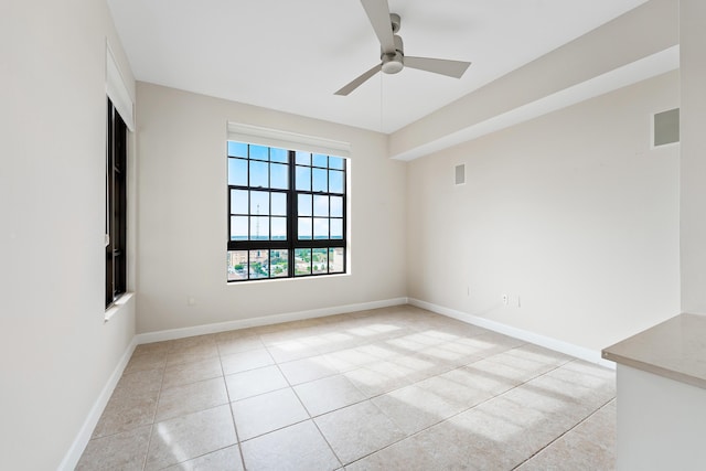 tiled spare room featuring ceiling fan