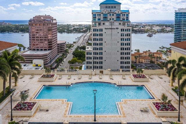 view of pool with a patio area and a water view