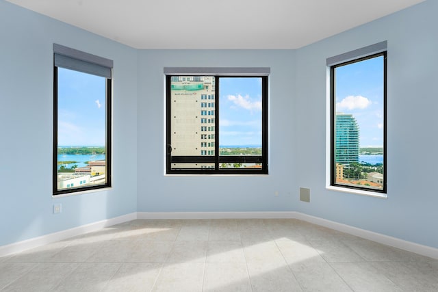 tiled spare room with a water view