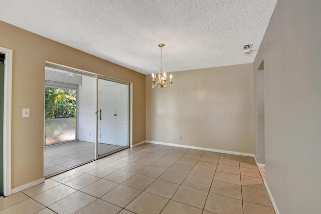 interior space featuring a chandelier, light tile patterned floors, and a textured ceiling