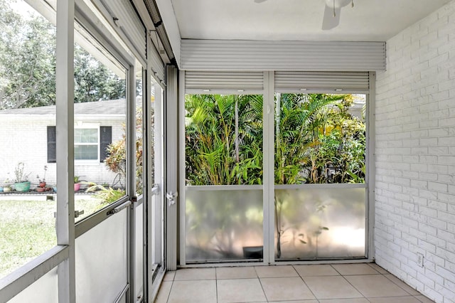 unfurnished sunroom featuring ceiling fan and plenty of natural light