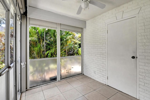 unfurnished sunroom featuring ceiling fan