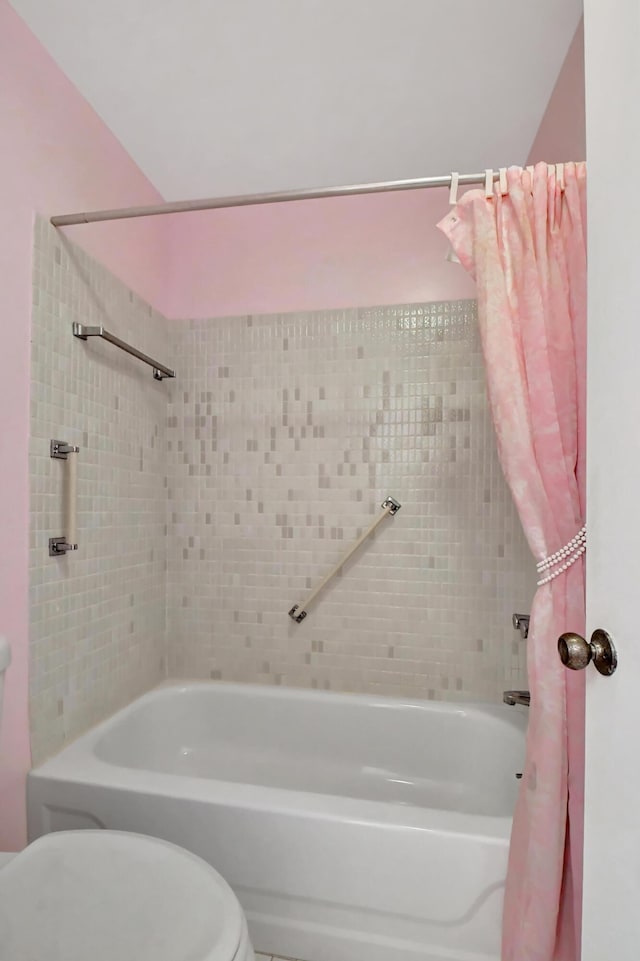 bathroom with toilet and shower / bath combo with shower curtain