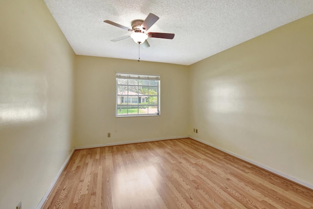 unfurnished room with ceiling fan, a textured ceiling, and light wood-type flooring