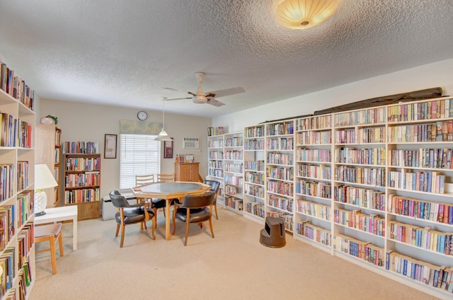 interior space featuring ceiling fan, carpet, and a textured ceiling