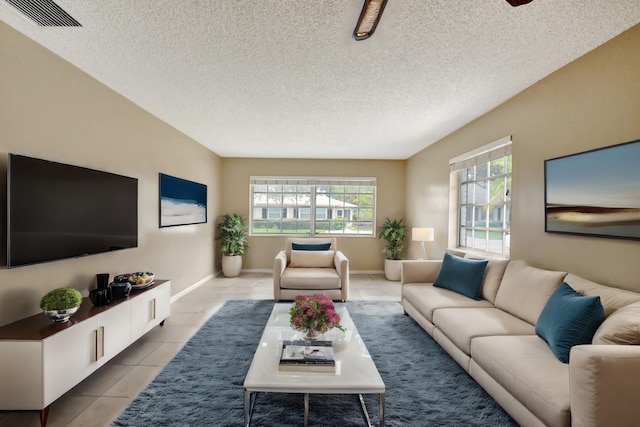 tiled living room with a textured ceiling and a healthy amount of sunlight