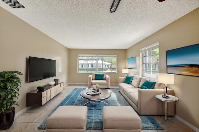 living room featuring plenty of natural light, light tile patterned floors, and a textured ceiling