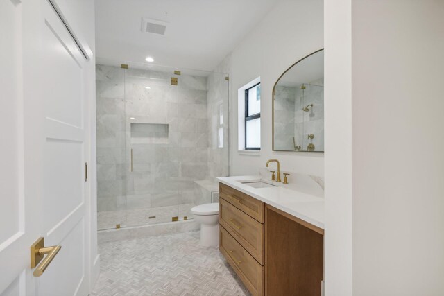 bathroom featuring vanity, toilet, and walk in shower