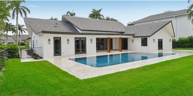 back of house with a patio and a lawn