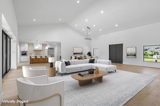 living room featuring light hardwood / wood-style floors and high vaulted ceiling