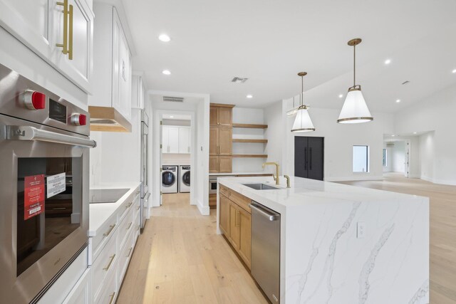 kitchen featuring white cabinetry, pendant lighting, and an island with sink