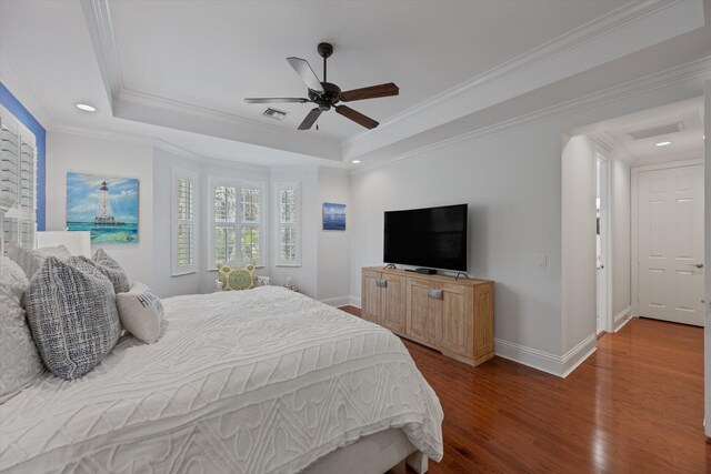 bedroom featuring hardwood / wood-style floors, ornamental molding, ceiling fan, and a raised ceiling