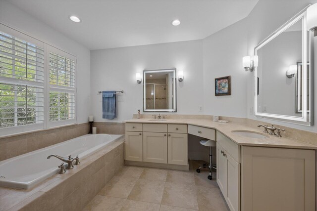 bathroom with tile flooring, dual vanity, and tiled bath