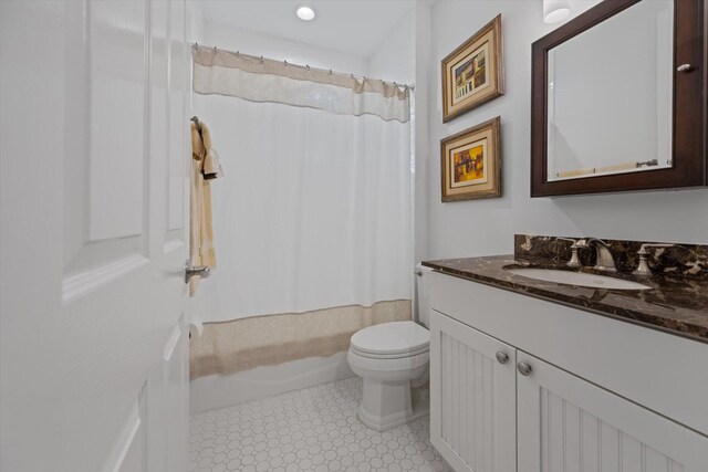 full bathroom with tile floors, large vanity, toilet, and shower / tub combo with curtain