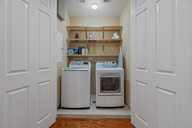 washroom with washer and dryer and wood-type flooring