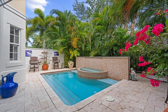 view of swimming pool featuring a patio area and an in ground hot tub