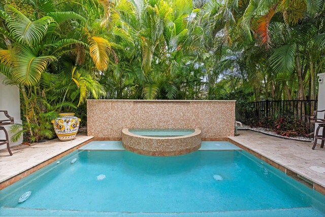 view of swimming pool with a patio and an in ground hot tub