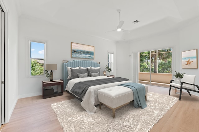 bedroom with ceiling fan, multiple windows, and light hardwood / wood-style floors