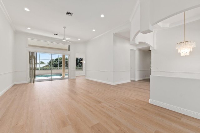 interior space with light wood-type flooring, ceiling fan with notable chandelier, and ornamental molding