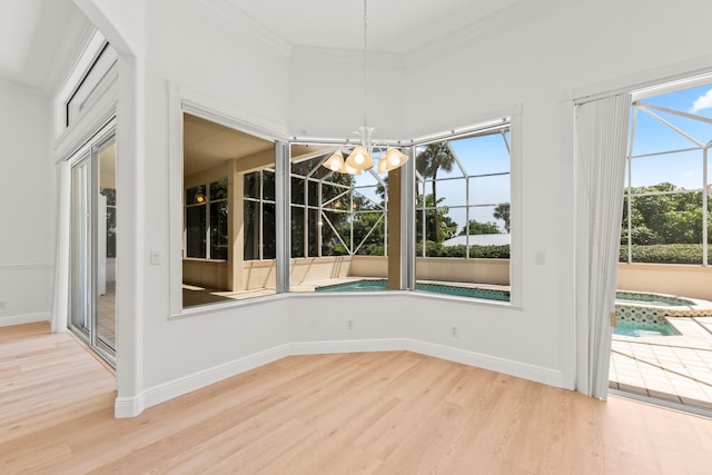 unfurnished dining area with ornamental molding, a notable chandelier, and light hardwood / wood-style flooring