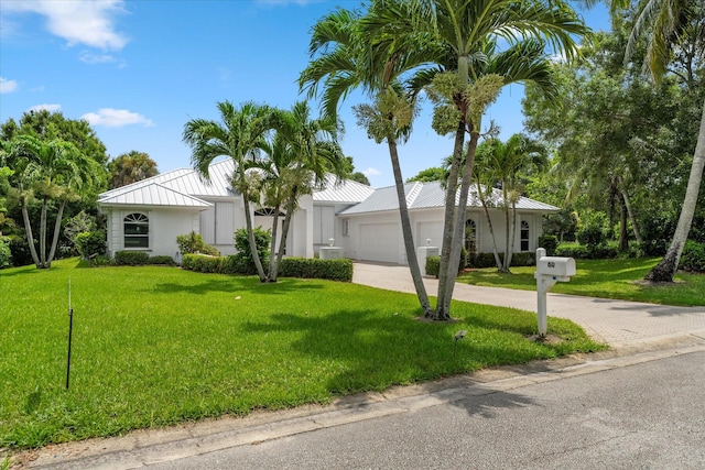 view of front of home with a garage and a front lawn