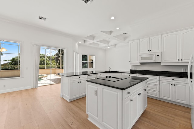 kitchen featuring light wood-type flooring, coffered ceiling, white appliances, and white cabinetry