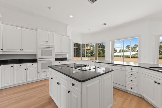 kitchen featuring light wood-type flooring, white cabinets, white appliances, and a kitchen island