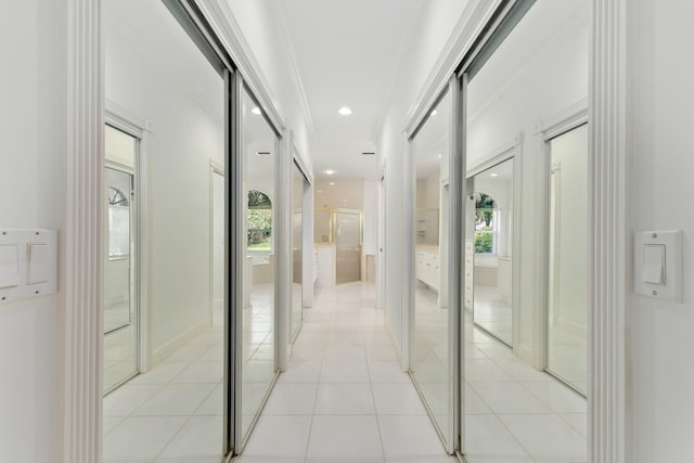 corridor featuring crown molding and light tile patterned floors