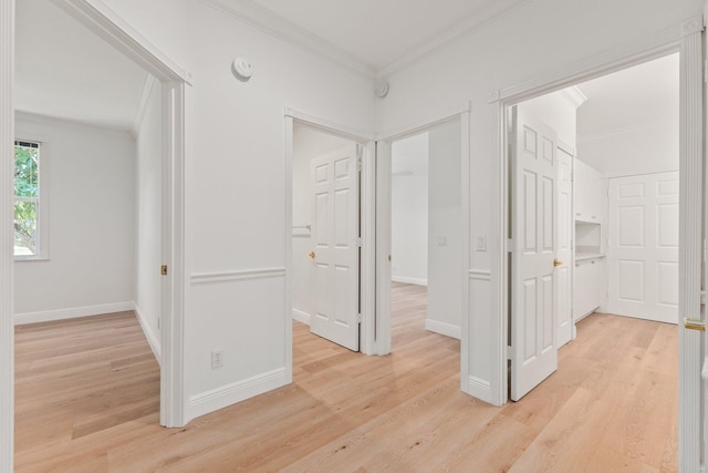 spare room with light wood-type flooring and crown molding