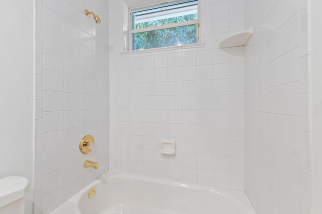 bathroom with tiled shower / bath and toilet