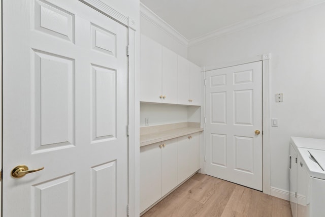 kitchen featuring crown molding, washing machine and dryer, light hardwood / wood-style flooring, and white cabinetry