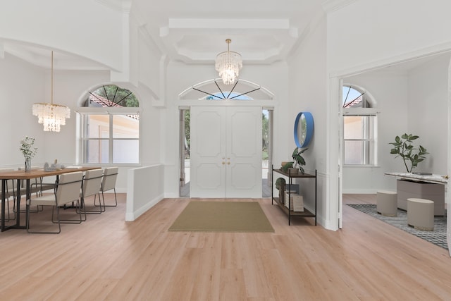 foyer entrance featuring a wealth of natural light, light hardwood / wood-style floors, and a notable chandelier