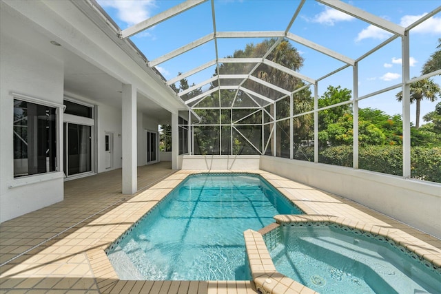 view of pool with glass enclosure, an in ground hot tub, and a patio