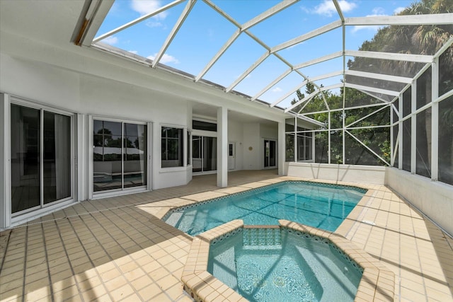 view of pool with glass enclosure, a patio area, and an in ground hot tub