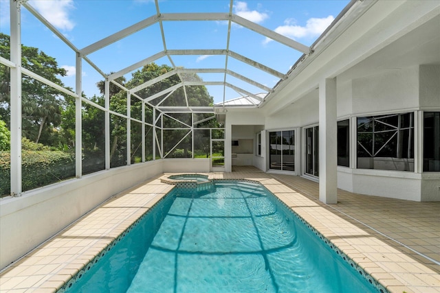 view of swimming pool featuring glass enclosure, a patio area, and an in ground hot tub