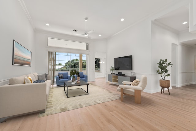 living room featuring light wood-type flooring, ornamental molding, and ceiling fan