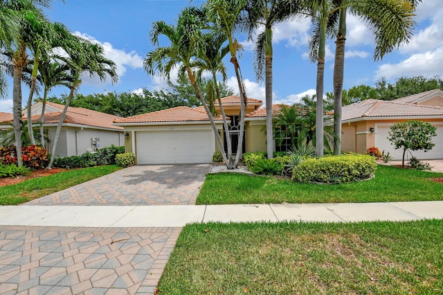 mediterranean / spanish-style house with a garage and a front lawn