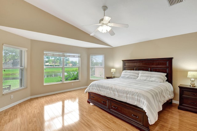 bedroom featuring multiple windows, ceiling fan, vaulted ceiling, and light wood-type flooring