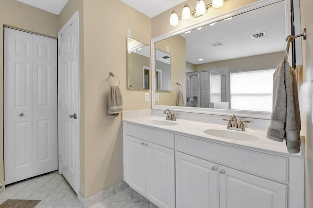 bathroom with tile flooring, vanity with extensive cabinet space, and double sink