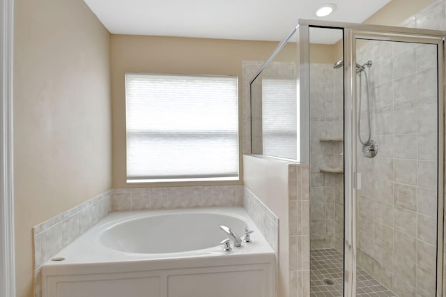 bathroom featuring a wealth of natural light and separate shower and tub