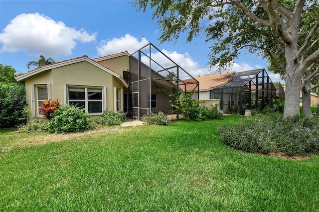 back of property featuring a lawn and a lanai